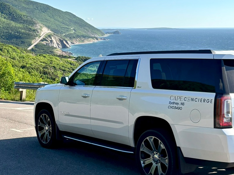 Luxury Yukon Denali SUV on Cabot Trail overlooking Cape Breton coastline
